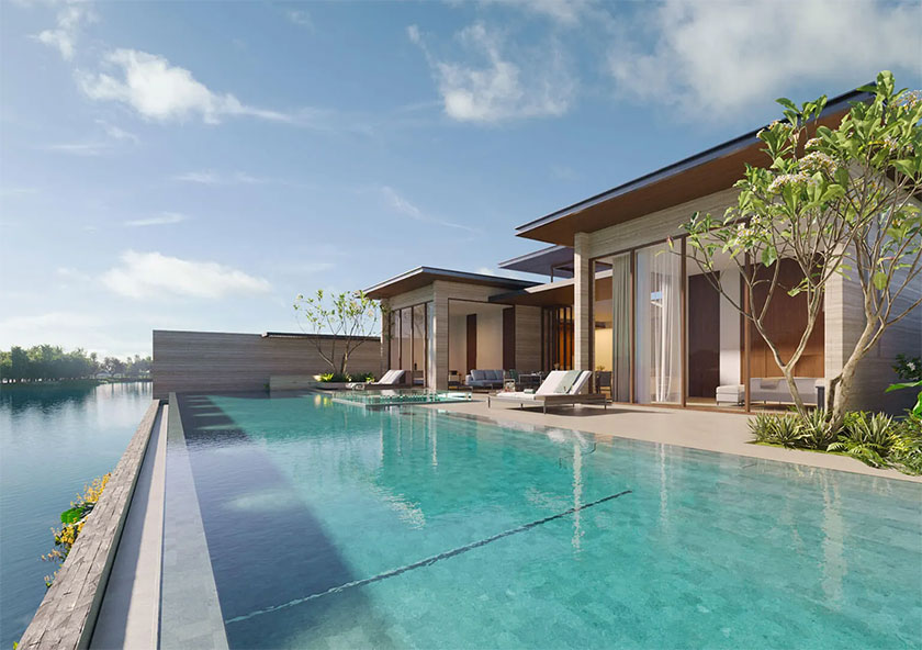 Banyan Tree Grand Residences Lagoon Pool Villas | A modern villa with expansive windows is adjacent to an infinity pool, overlooking a tranquil body of water, under a clear sky.