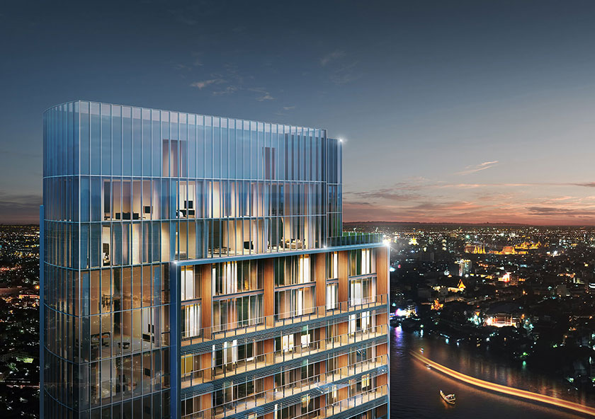 Banyan Tree Residences Riverside Bangkok | A modern multi-story building with glass facade illuminated against a dusk skyline with city lights and a river.