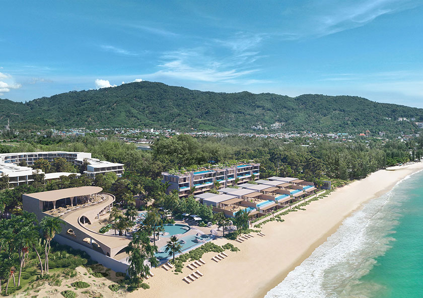 บันยันทรี บีช เรสซิเดนซ์ มาซู- A coastal resort with modern buildings is nestled between a hillside and a sandy beach with clear blue water, under a cloudy sky.