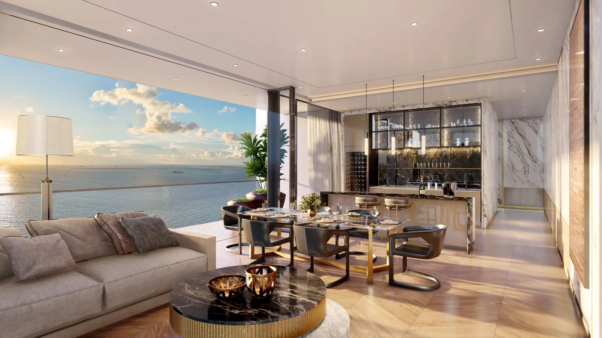 Banyan Tree Residences Manila Bay - A luxurious open-plan living space features a dining area and lounge with a view of the sea at sunset.